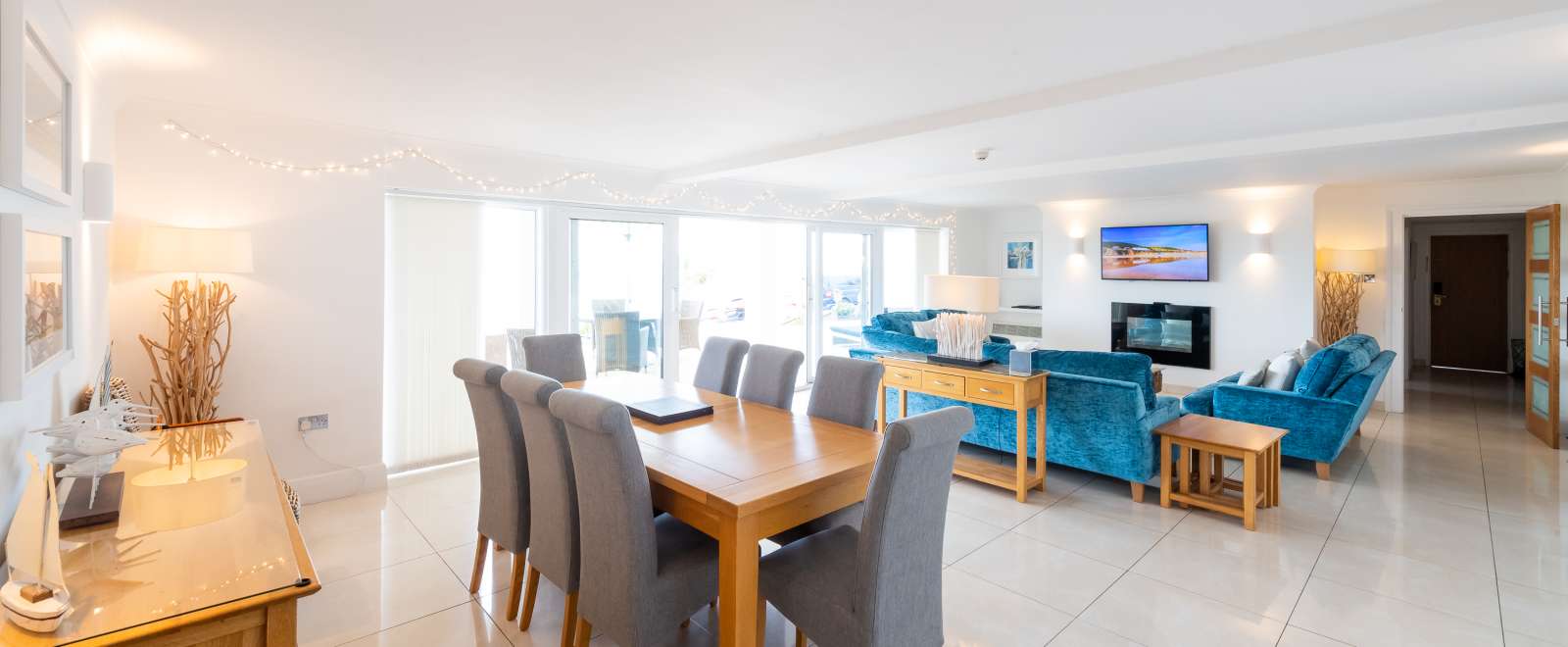 Surf lounge area with dining table, chairs and blue velvet sofas