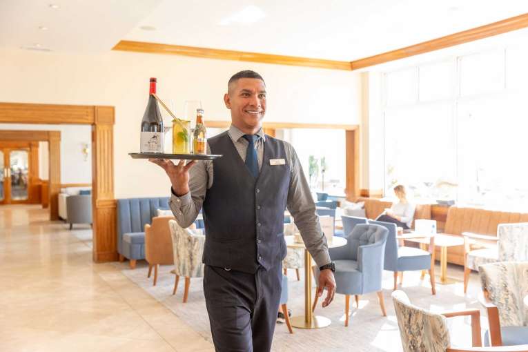 Barman carrying tray of drinks