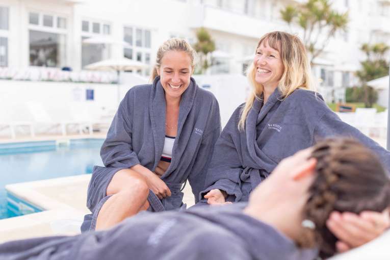 Group of women relaxing by the outdoor pool