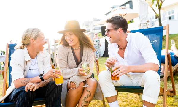 Three friends sat on the deck chairs with cocktails