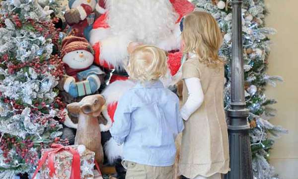 two children looking at father Christmas